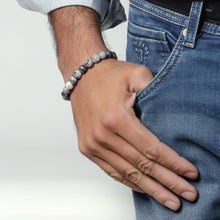 Load image into Gallery viewer, Lifestyle shot of a Black Picasso Jasper bracelet on a person's wrist, emphasizing comfort and beauty.