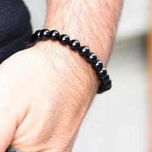 Load image into Gallery viewer, Lifestyle shot of a Black Onyx bracelet on a person's wrist, emphasizing comfort and beauty.