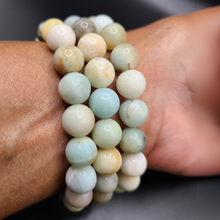 Load image into Gallery viewer, Lifestyle shot of a Amazonite bracelet on a person's wrist, emphasizing comfort and beauty.