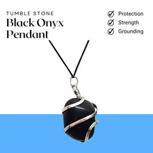 Load image into Gallery viewer, Black onyx pendant wrapped in silver wire hanging on a cord, placed on natural wood.