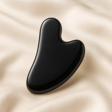 Load image into Gallery viewer, Black Obsidian Gua Sha displayed fully on white silk cloth to show its natural colour, shape and finish