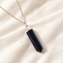 Load image into Gallery viewer, Blue Goldstone Pencil Pendant displayed fully on white silk cloth to show its natural colour, shape and finish