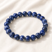 Load image into Gallery viewer, Lapis Lazuli Bracelet displayed fully on white silk cloth to show its natural colour, shape and finish