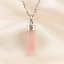 Load image into Gallery viewer, Rose Quartz Pencil Pendant displayed fully on white silk cloth to show its natural colour, shape and finish