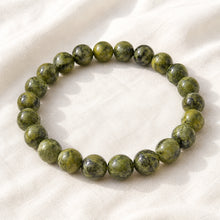 Load image into Gallery viewer, Serpentine Bracelet displayed fully on white silk cloth to show its natural colour, shape and finish