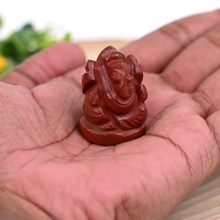 Load image into Gallery viewer, Red Jasper Ganesh crystal figurine held in hand, symbolizing protection, strength and success with natural healing energy.