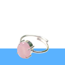 Load image into Gallery viewer, Rose Quartz diamond cut oval ring on a white and blue minimalist background, promoting love, compassion and emotional healing.