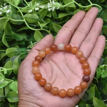 Load image into Gallery viewer, Lifestyle shot of a Red Aventurine bracelet on a person&#39;s wrist, emphasizing comfort and beauty.
