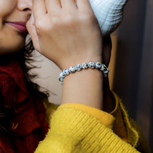 Load image into Gallery viewer, Lifestyle shot of a Dalmation Jasper bracelet on a person's wrist, emphasizing comfort and beauty.
