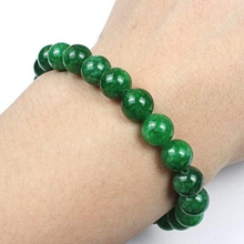 Load image into Gallery viewer, Lifestyle shot of a Green Jade bracelet on a person's wrist, emphasizing comfort and beauty.
