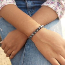 Load image into Gallery viewer, Lifestyle shot of a Larvikite bracelet on a person&#39;s wrist, emphasizing comfort and beauty.
