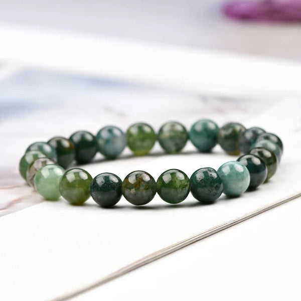 Lifestyle shot of a Moss Agate bracelet on a person's wrist, emphasizing comfort and beauty.