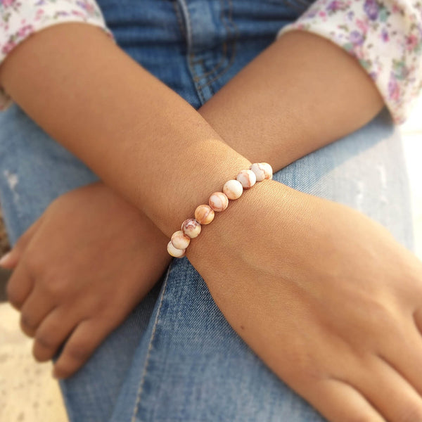 Lifestyle shot of a Red Picasso Jasper bracelet on a person's wrist, emphasizing comfort and beauty.