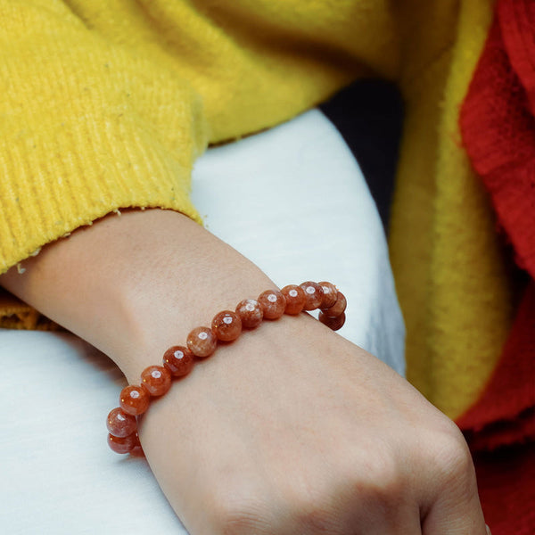 Lifestyle shot of a Red Sunstone bracelet on a person's wrist, emphasizing comfort and beauty.
