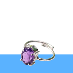 Amethyst diamond cut oval ring on a clean white and blue minimalist background, promoting intuition, clarity and inner peace.
