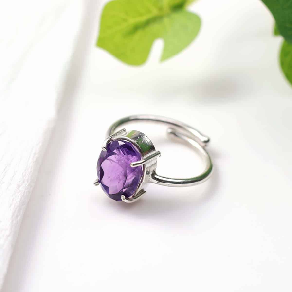 Amethyst diamond cut oval ring placed on a white table, promoting spiritual awareness, intuition and inner peace.