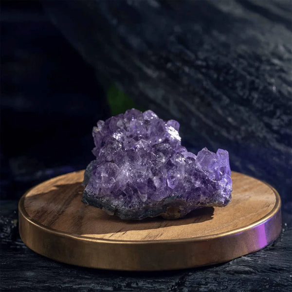 Amethyst raw stone cluster placed on a wooden table, symbolizing calm, insight, and protection.