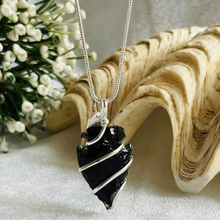 Load image into Gallery viewer, Black obsidian arrowhead pendant with chain displayed on a silver background with decorative flowers
