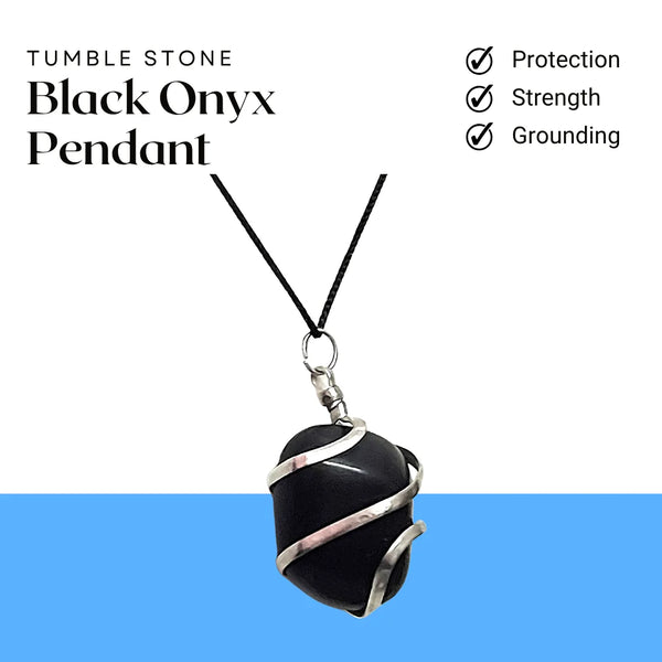 Black onyx pendant wrapped in silver wire hanging on a cord, placed on natural wood.