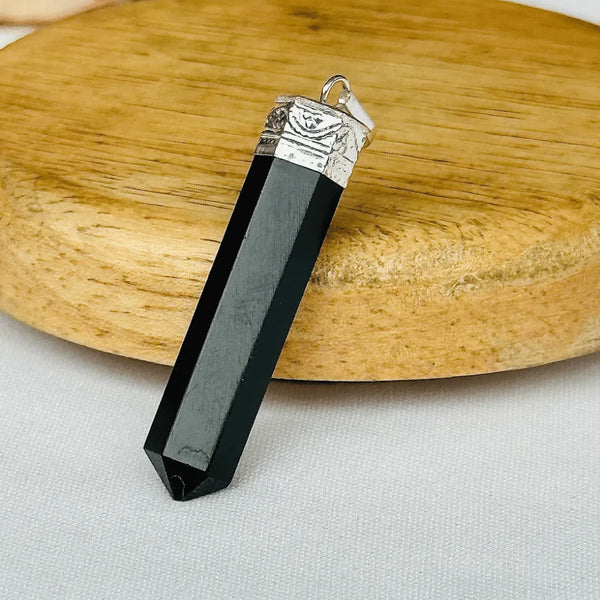 Black Onyx point pendant with silver cap and chain displayed on a clean white background.