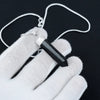 Black Tourmaline pencil necklace laid across a relaxed palm, photographed top-down with clear detail and soft shadows.