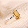 Close-up of Citrine diamond cut oval ring on a textured fabric surface, symbolizing success, prosperity and positive energy.