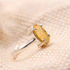 Close-up of Citrine diamond cut oval ring on a textured fabric surface, symbolizing success, prosperity and positive energy.