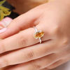 Close-up of a Citrine oval diamond cut ring worn on a finger, symbolizing wealth, success and confidence.