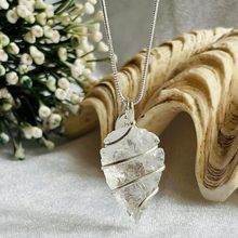 Load image into Gallery viewer, Clear quartz arrowhead pendant with chain displayed on a silver metallic background
