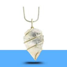 Load image into Gallery viewer, Natural clear quartz arrowhead pendant with silver chain placed on a half-blue, half-white backdrop
