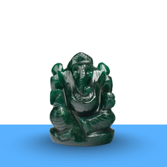 Dark green Ganesh stone figurine, front view on minimalist white and blue background, polished carved details