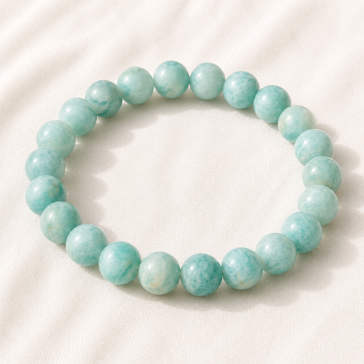 Amazonite Bracelet displayed fully on white silk cloth to show its natural colour, shape and finish