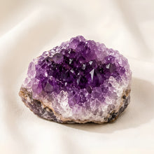 Load image into Gallery viewer, Amethyst Raw Stone displayed fully on white silk cloth to show its natural colour, shape and finish
