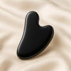Black Obsidian Gua Sha displayed fully on white silk cloth to show its natural colour, shape and finish