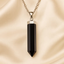 Load image into Gallery viewer, Black Obsidian Pencil Pendant displayed fully on white silk cloth to show its natural colour, shape and finish
