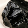 Close-up of authentic natural Black Obsidian showing crystal texture, colour and craftsmanship – black obsidian raw stone symbol of protection grounding and