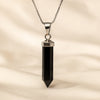 Black Onyx Pencil Pendant displayed fully on white silk cloth to show its natural colour, shape and finish