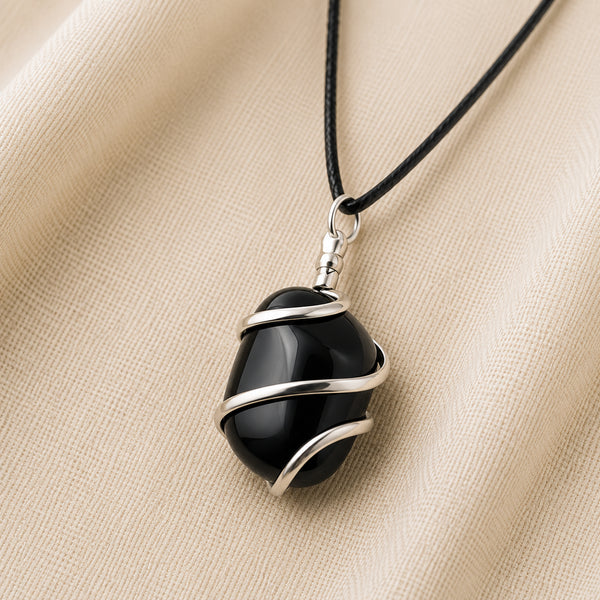 Black Onyx Tumble Pendant displayed fully on white silk cloth to show its natural colour, shape and finish