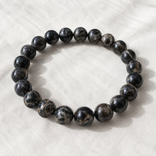Load image into Gallery viewer, Black Picasso Jasper Bracelet displayed fully on white silk cloth to show its natural colour, shape and finish
