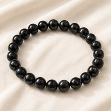 Load image into Gallery viewer, Black Tourmaline Bracelet displayed fully on white silk cloth to show its natural colour, shape and finish
