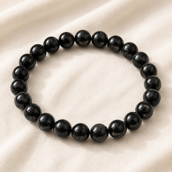Black Tourmaline Bracelet displayed fully on white silk cloth to show its natural colour, shape and finish