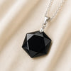 Black Tourmaline Hexagon Pendant displayed fully on white silk cloth to show its natural colour, shape and finish