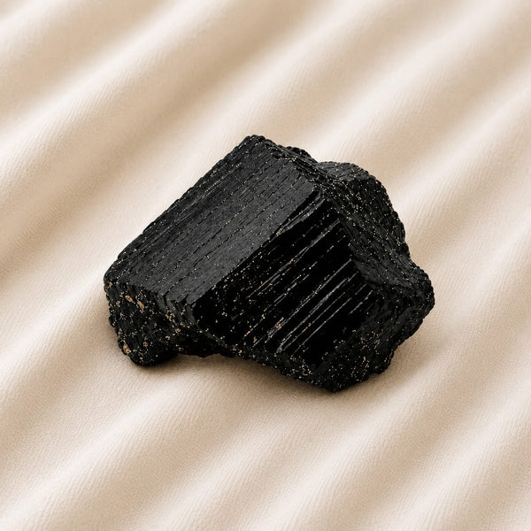 Black Tourmaline Raw Stone displayed fully on white silk cloth to show its natural colour, shape and finish