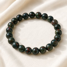 Load image into Gallery viewer, Bloodstone Bracelet displayed fully on white silk cloth to show its natural colour, shape and finish

