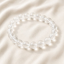 Load image into Gallery viewer, Clear Quartz Bracelet displayed fully on white silk cloth to show its natural colour, shape and finish

