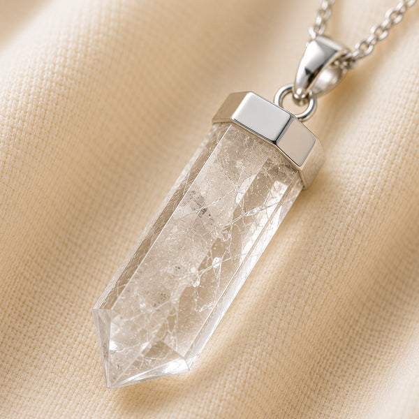 Clear Quartz Pencil Pendant displayed fully on white silk cloth to show its natural colour, shape and finish
