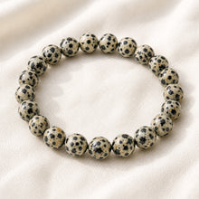 Load image into Gallery viewer, Dalmatian Jasper Bracelet displayed fully on white silk cloth to show its natural colour, shape and finish

