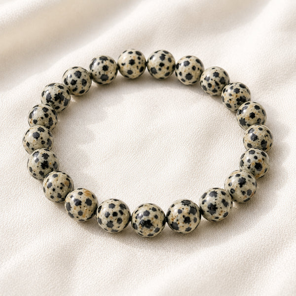 Dalmatian Jasper Bracelet displayed fully on white silk cloth to show its natural colour, shape and finish