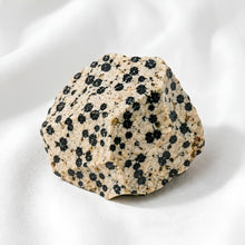 Load image into Gallery viewer, Dalmatian Jasper Raw Stone displayed fully on white silk cloth to show its natural colour, shape and finish
