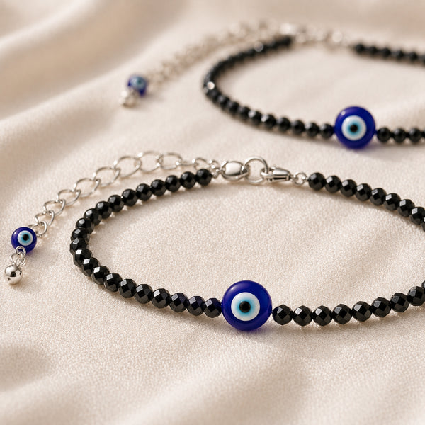 Evil Eye with Black Tourmaline Anklet with Free Selenite Charging Plate displayed fully on white silk cloth to show its natural colour, shape and finish